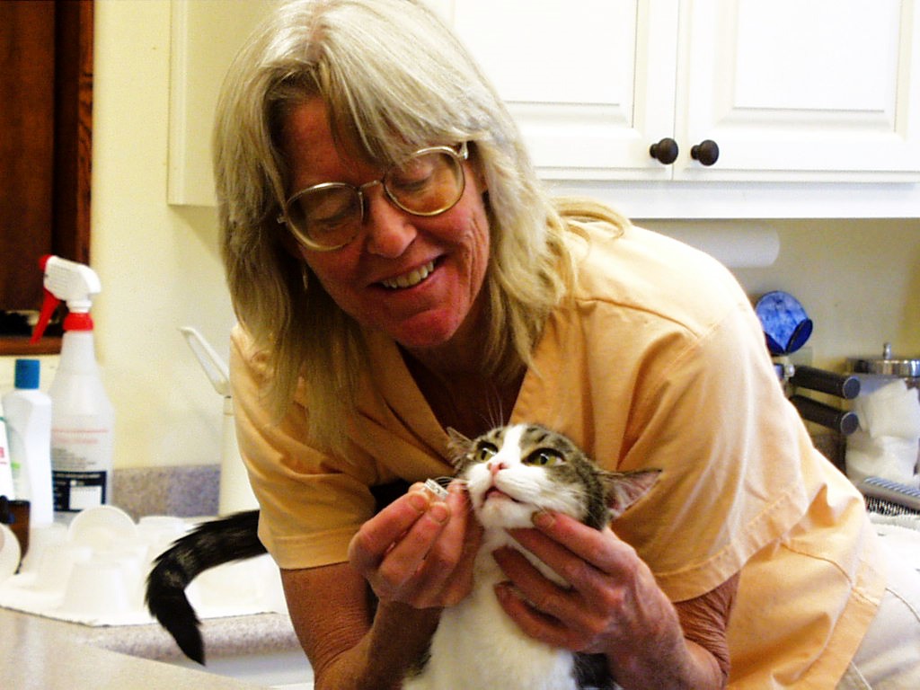 a woman trying to feed a cat medicine