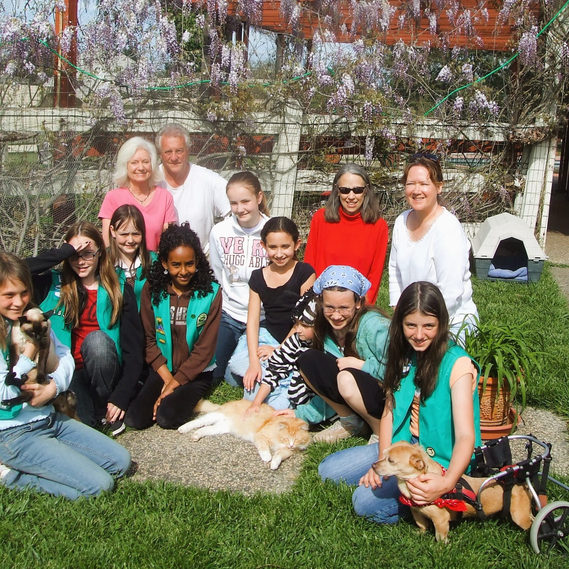 Gail and Richard with a group of kids surrounded by animals that suffer chronic conditions