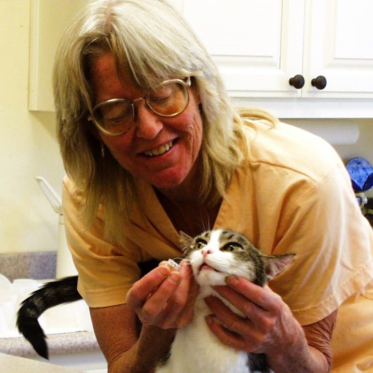a woman trying to feed a cat medicine