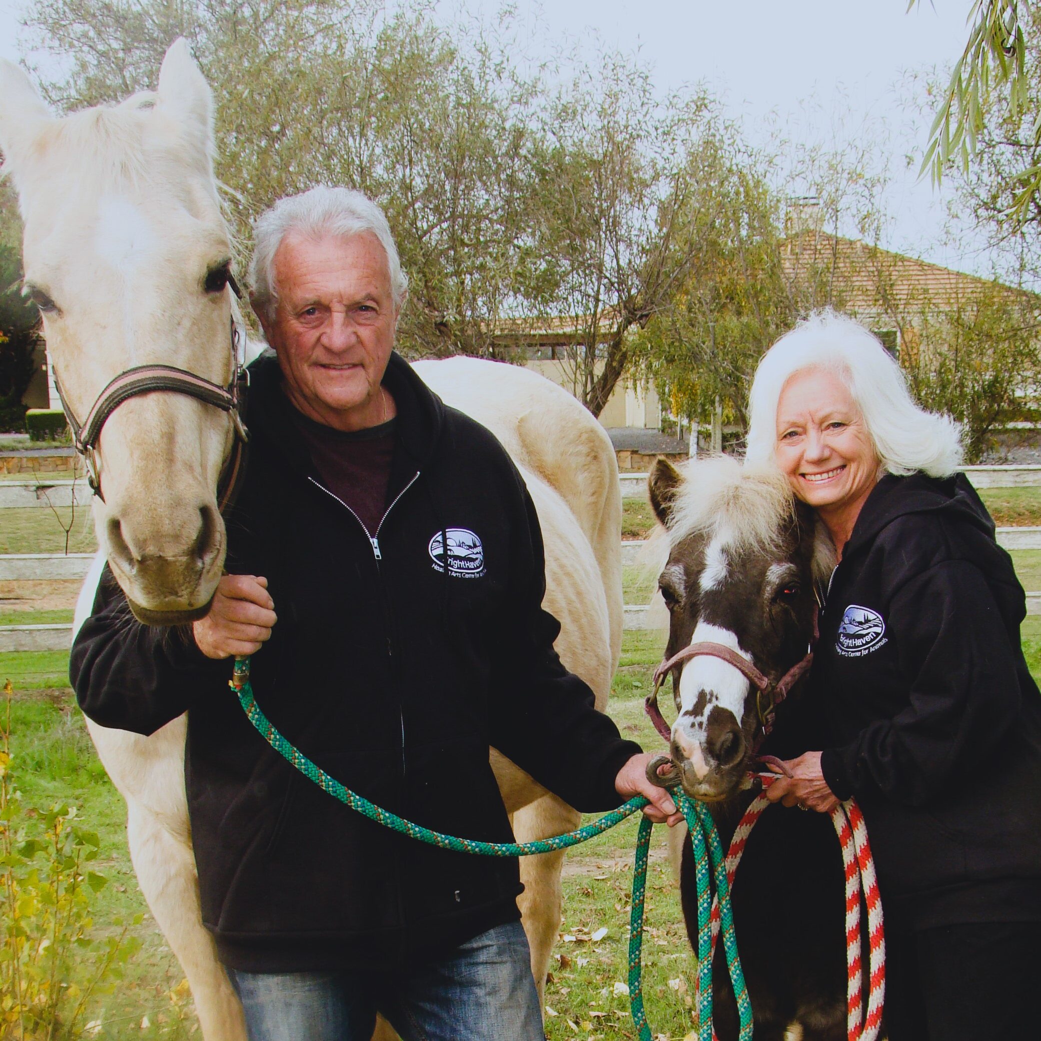 Gail and Richard Pope with one white horse and one brown horse